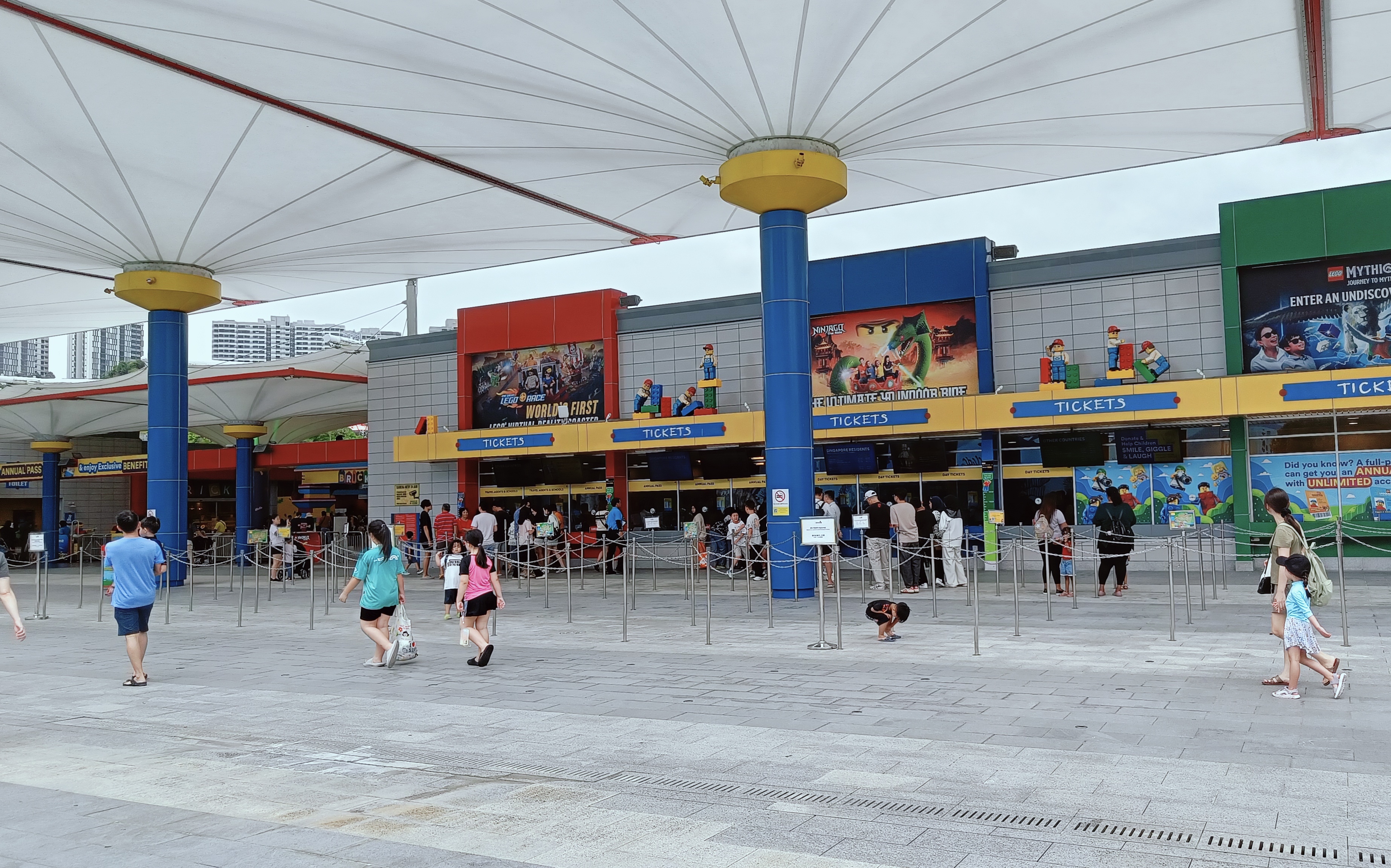 Colorful entrance of Legoland Malaysia Theme Park with families and kids entering for a day of fun.